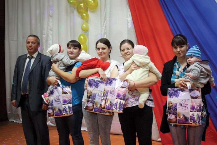 В.В. Покровский вручает памятные подарки семьям, где появились новорожденные